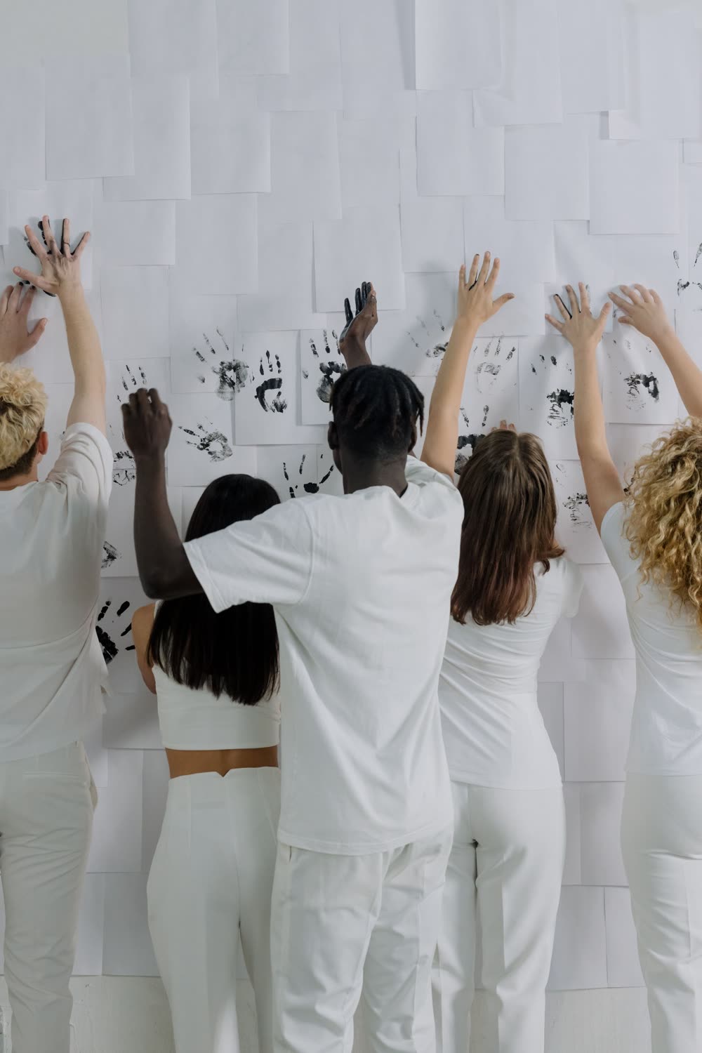 Diverse community members leaving their handprints on a shared wall